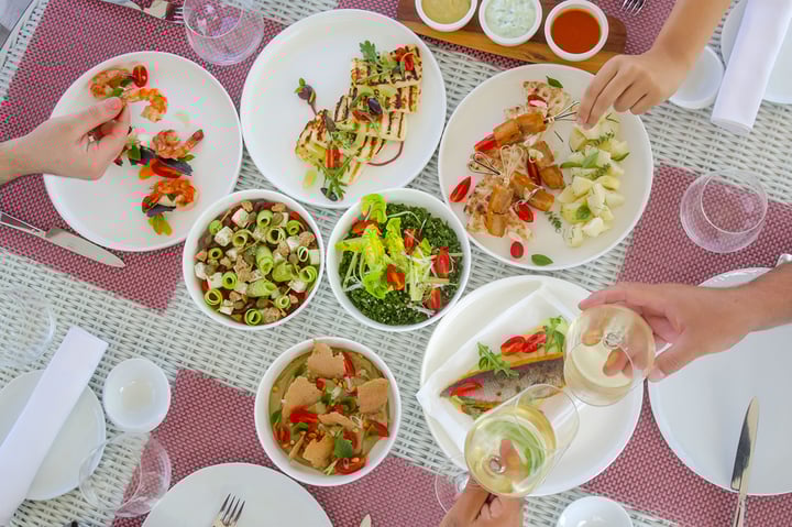 Avaton Hotels restaurant table full of food and the guest enjoying