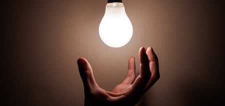 An image of a lightbulb and a hand