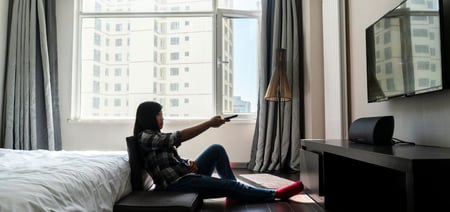 A guest watching tv in a hotel room 