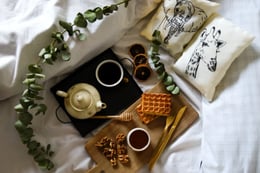 room service tray with waffles and tea on a bed-1