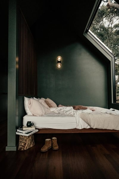 Bed under a window with a view into nature