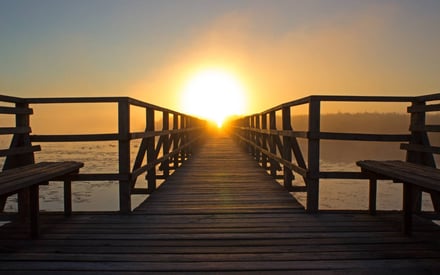 Eine Brücke mit untergehender Sonne am Horizont