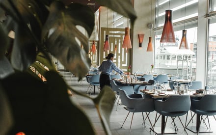 Eine Servicemitarbeiterin des Hotelrestaurants beim Eindecken der Tischen