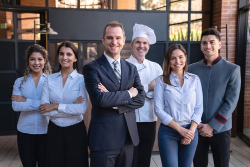 Six hotel employees smiling at the camera
