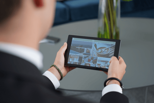 A Les Roches staff holding a SuitePad tablet