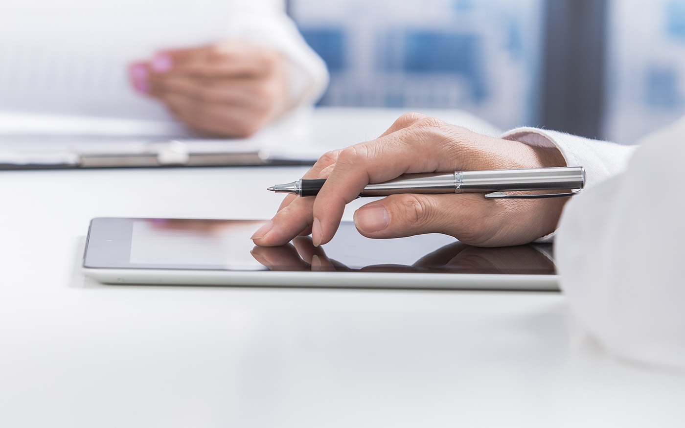 Hands on a tablet signing a document