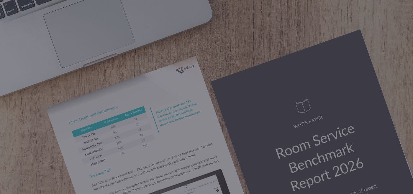 Two pages of the report on a wooden table next to a laptop