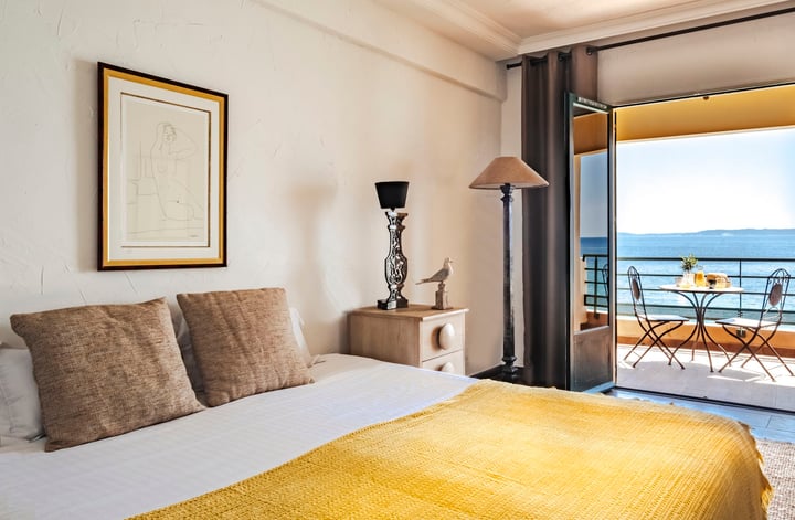 Hotel room at Dokhan Luxury Hotels’ Surplage Hotel, featuring yellow accents and a seaside view