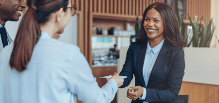 A front office manager checking in two guests 