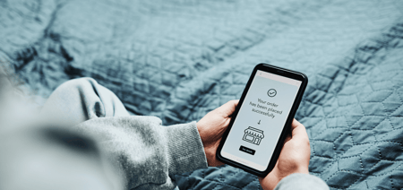 a person holding a mobile phone after ordering on their phone