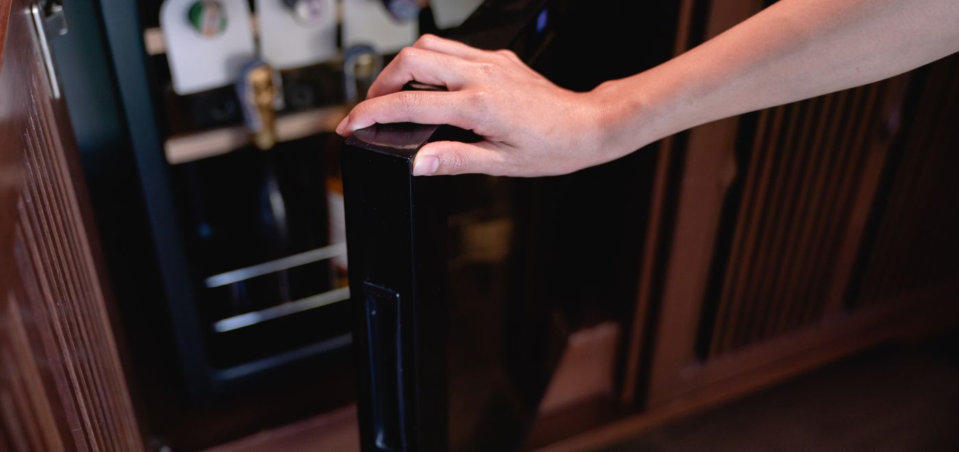 Hand öffnet Minibar