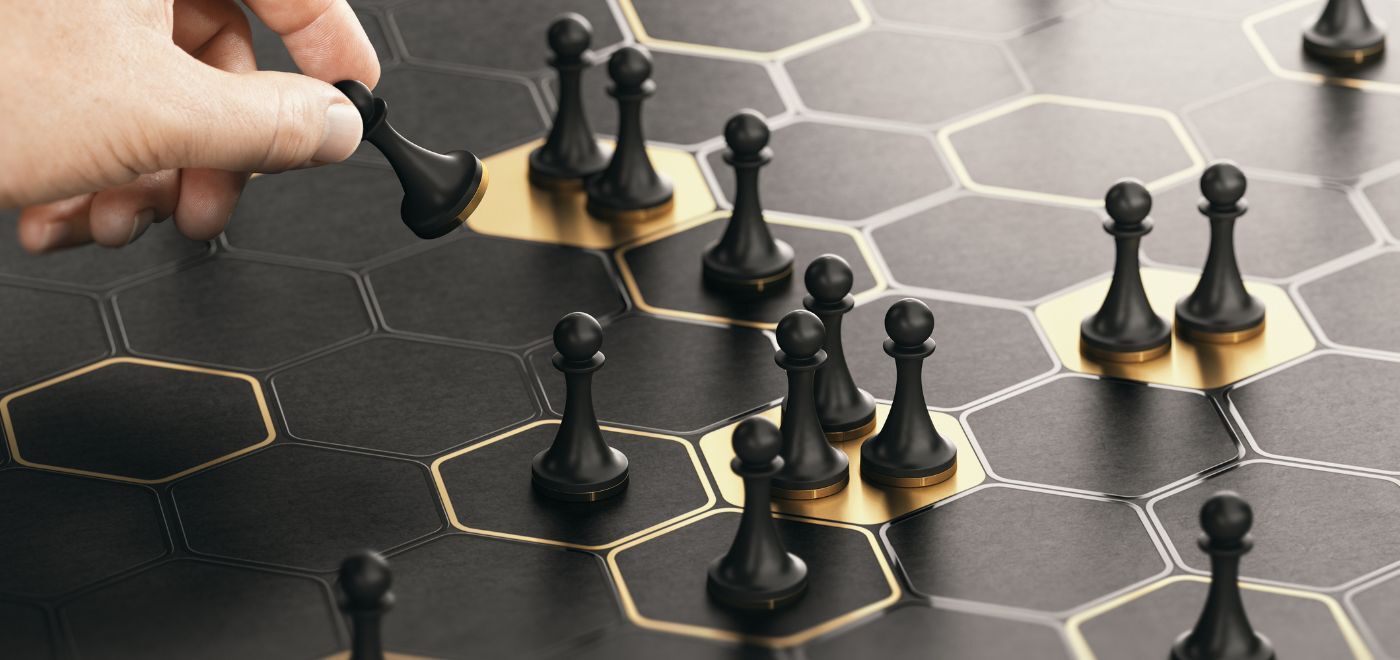 A ches board with multiple pawn and a hand moving the pieces symbolizing integrations within hotel tech stack