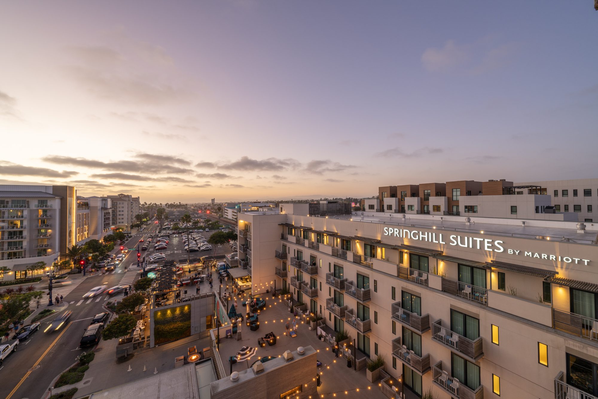 SpringHill Suites Oceanside Beach exterior and rooftop terrace at dusk, a Marriott select-service hotel near Oceanside Pier in Southern California