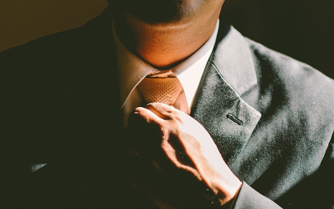 Man tightens neck tie before starting work